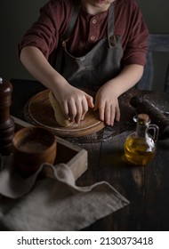 Kid Making Dough On Wooden Table With Ingredients Flour, Oil, Salt, Dark Background. Copy Space. Home Bakery Concept, Kitchen Cooking Story.