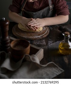 Kid Making Dough On Wooden Table With Ingredients Flour, Oil, Salt, Dark Background. Copy Space. Home Bakery Concept, Kitchen Cooking Story.