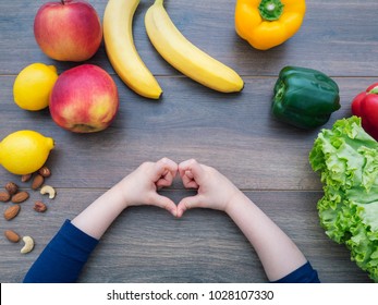 Kid Making Heart Shape With Her Hands And Healthy Food On The Table, Top View