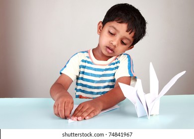 A Kid Making A Origami Bird