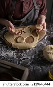 Kid Making Pelmeni (meet Dumplings) Of Dough On Wooden Table With Ingredients Flour, Oil, Salt, Dark Background. Copy Space. Home Bakery Concept, Kitchen Cooking Story.