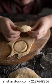 Kid Making Pelmeni (meet Dumplings) Of Dough On Wooden Table With Ingredients Flour, Oil, Salt, Dark Background. Copy Space. Home Bakery Concept, Kitchen Cooking Story.