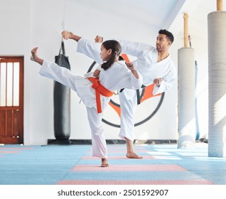 Kid, master or kick in martial arts dojo for training, fighting exercise or karate club education. Learning skill, practice or judo teacher with girl child in studio for taekwondo lesson or workout