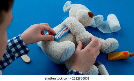 Kid Is Measuring The Temperature Of His Toy, Selective Focus. Concept Of Health Care