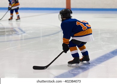 Kid Minor Ice Hockey Player Gets Ready For A Face-off