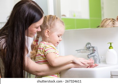 Kid And Mother Washing Hands With Soap In Bathroom