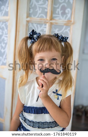 kid moustache concept - fun 4-year old Charlie Chaplin look alike dressing up with a fake mustache