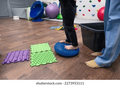 Kid on Sensory Mat Massage during sensory integration session. child girl in rehabilitation centre with physiotherapist doing orthopedic correction.  - Powered by Shutterstock
