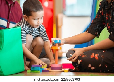 Kid with parents playing educational toys, arranging, sorting colors and shapes together in children's playroom. Learning through experience conception. - Shutterstock ID 2286303903