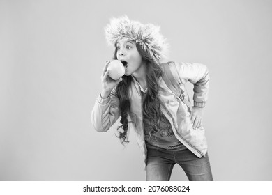 Kid Pink Background. Teen Daily Life. Education And Happy Kids. Schoolgirl With Books After Lesson. School Break. Small Happy Girl Earflap Hat Eat Apple. End Of Winter Semester. Holiday And Vacation.