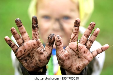 Kid Play In A Garden And Show Dirty Muddy Hands.