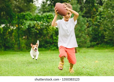 Kid Playing American Football Ready To Make Touchdown And Dog Chasing Him