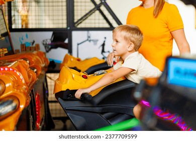 Kid playing arcade simulator machine at an amusement park.