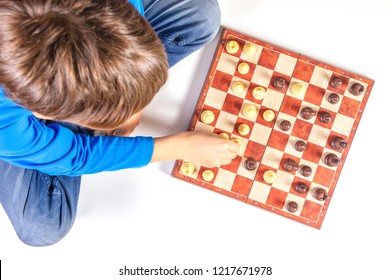 Kid Playing Chess Game On Chessboard. Top View