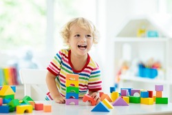 Criança Brincando Com Blocos De Brinquedos Coloridos. Garotinho Construindo Torre De Brinquedos De Bloco. Brinquedos E Jogos Educativos E Criativos Para Crianças Pequenas. Bebê No Quarto Branco Com Tijolos De Arco-íris. Criança Em Casa.