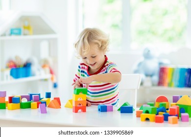 Kid playing with colorful toy blocks. Little boy building tower of block toys. Educational and creative toys and games for young children. Baby in white bedroom with rainbow bricks. Child at home. - Shutterstock ID 1339905869