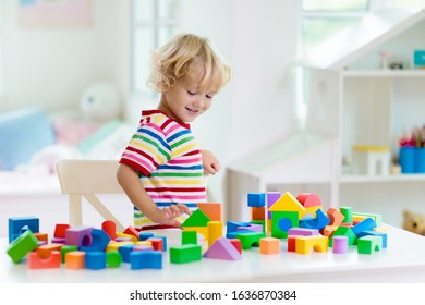 Kid playing with colorful toy blocks. Little boy building tower of block toys. Educational and creative toys and games for young children. Baby in white bedroom with rainbow bricks. Child at home. - Shutterstock ID 1636870384