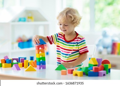 Kid playing with colorful toy blocks. Little boy building tower of block toys. Educational and creative toys and games for young children. Baby in white bedroom with rainbow bricks. Child at home. - Shutterstock ID 1636871935
