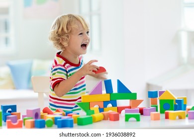 Kid playing with colorful toy blocks. Little boy building tower of block toys. Educational and creative toys and games for young children. Baby in white bedroom with rainbow bricks. Child at home. - Shutterstock ID 1936038892