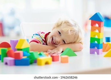 Kid Playing With Colorful Toy Blocks. Little Boy Building Tower Of Block Toys. Educational And Creative Toys And Games For Young Children. Baby In White Bedroom With Rainbow Bricks. Child At Home.