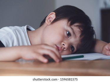 Kid Playing Colour Pencil Sitting Alone And Looking Down With Bored Face, Preschool Child Boy Laying Head Down On Table Looking Out Deep In Thought, Five Year Old Kid Bored With School Homework