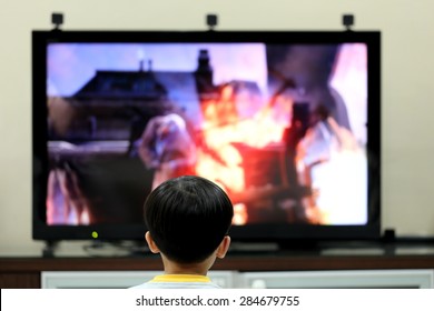 Kid Playing Console Game in Front of TV Monitor