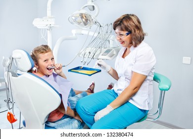 Kid Playing With Dental Drill During  Her First Pediatric Dentist Visit