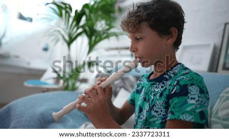 Kid playing flute young boy plays musical instrument