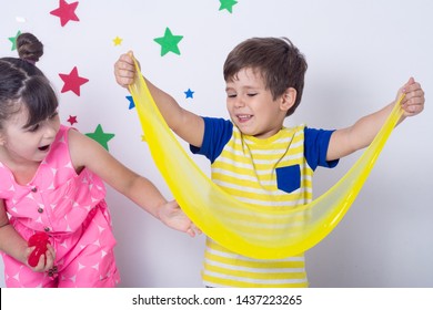 Kid playing hand made toy called slime. Children play with big yellow slime. Kid squeeze and stretching slime. 