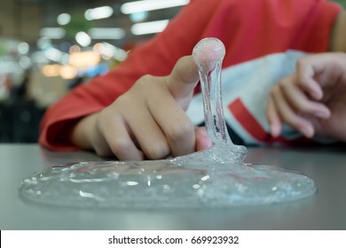 Kid Playing Hand Made Toy Called Slime, Selective Focus On Slime, Teenager Having Fun And Being Creative Homemade Slime. Young People Demonstration How Sticky Viscous Of Toy Thing After Experimental.