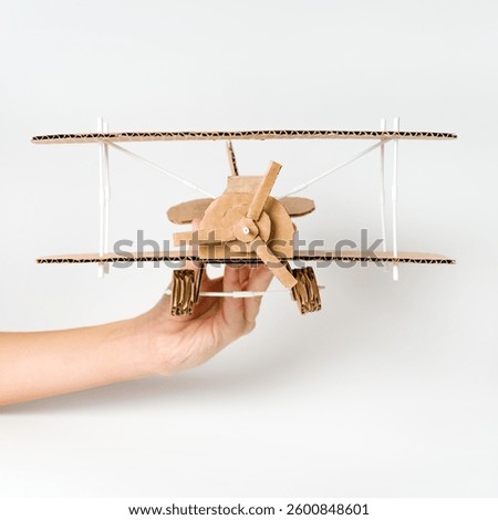 Kid playing with handcrafted biplane, creative aviation model
