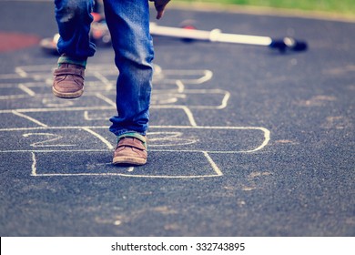 kid playing hopscotch on playground outdoors, children outdoor activities - Shutterstock ID 332743895