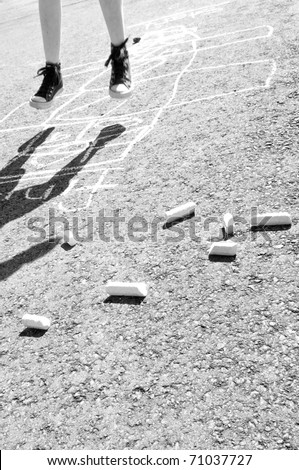 kid playing hopscotch on playground
