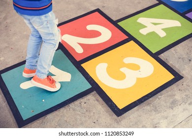 Kid Playing Hopscotch At School