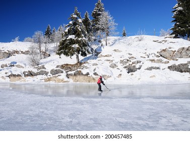 A kid playing ice hockey on a frozen lake, Canton Vaud, Switzerland - Shutterstock ID 200457485