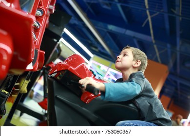 Kid playing in motorcycle simulator at indoor playground
