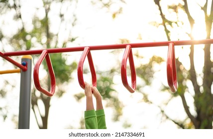 Kid playing on a children playground equipment, outdoor. Close up view of kid's hands on triangle monkey bars. - Powered by Shutterstock