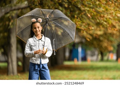 Kid playing out in the rain. Children with umbrella play outdoors in rain. autumn weather. - Powered by Shutterstock