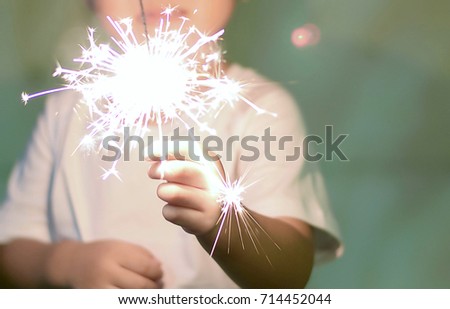 Kid playing sparklers.