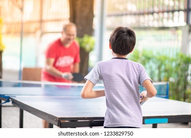 Kid Playing Table Tennis Outdoor With Family