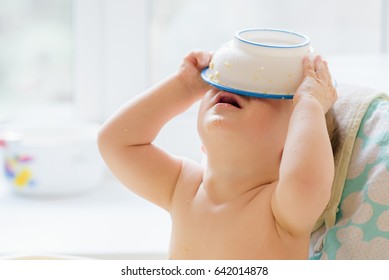 Kid Plays In The Kitchen With Dishes