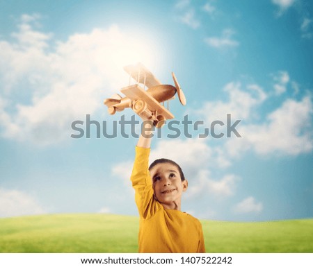 Kid plays with a wooden toy airplane