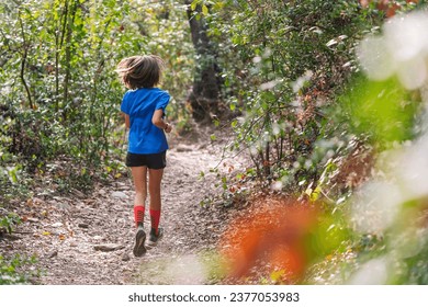 kid practicing trail running in the forest