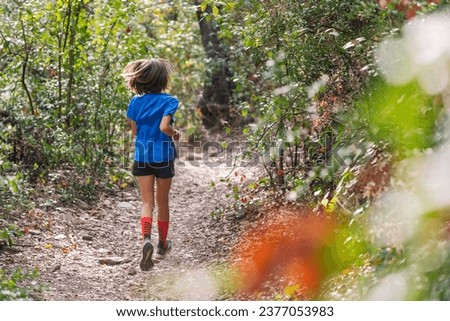 kid practicing trail running in the forest