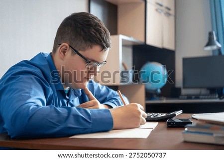 Kid preparing for school at home. A student does homework at a table with textbooks