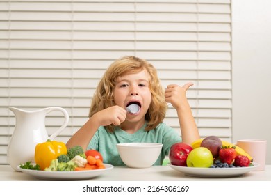 Kid Preteen Boy Lick Spoon In The Kitchen At The Table Eating Vegetable And Fruits During The Dinner Lunch. Healthy Food, Vegetable Dish For Children.