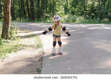 Kid In Protective Sportswear. Little Girl Learning To Roller Skate