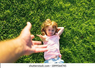 Kid pull father hand. Follow me, hand-in-hand walking on bright sunny day. Child holding man's hand and leading him on nature outdoor