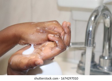 Kid Pumping Soap To Wash Hands In Sink