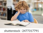 Kid reading book. Child reading book in school library. Learning from books. School education. Back to school Child reading book in a public library.